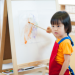 child painting on an easel