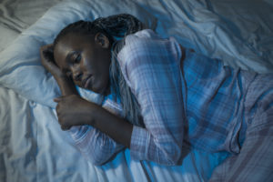 young African American woman lying on bed