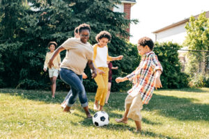 Mother playing soccer with a group of middle school age children